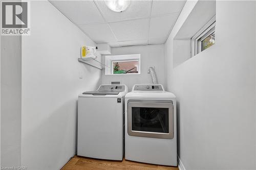 Laundry area featuring a drop ceiling, washer and clothes dryer, and light wood-style floors - 421 East 36Th Street, Hamilton, ON - Indoor Photo Showing Laundry Room