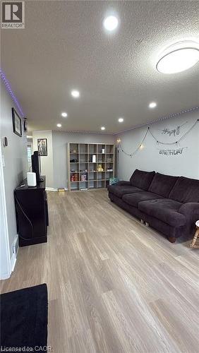 Living area featuring a textured ceiling, light wood-type flooring, and recessed lighting - 419 Downsview Place, Waterloo, ON - Indoor