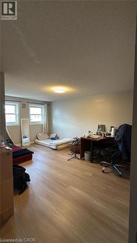 Bedroom featuring an office area, a textured ceiling, and light wood-style flooring - 419 Downsview Place, Waterloo, ON - Indoor