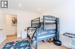 Bedroom with light wood finished floors and recessed lighting - 