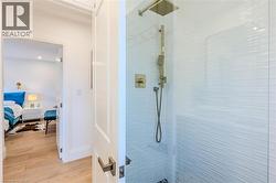 Ensuite bathroom featuring light wood finished floors and a walk in shower - 