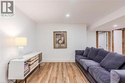 Living room with light wood-type flooring and recessed lighting - 