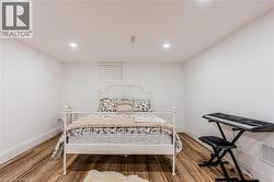 Bedroom with light wood finished floors and recessed lighting - 