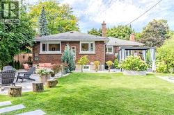 Rear view of property with a patio area, brick siding, a chimney, and a shingled roof - 