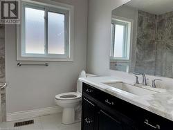 Bathroom featuring visible vents, vanity, baseboards, toilet, and marble finish floor - 