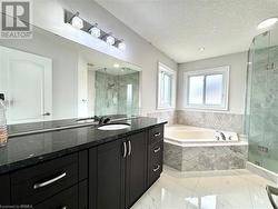Bathroom with a garden tub, a textured ceiling, a stall shower, vanity, and marble finish floor - 