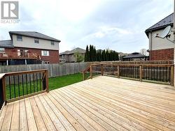 Wooden terrace with a fenced backyard, a lawn, and a residential view - 