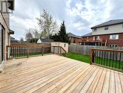 Wooden deck with a lawn, a storage shed, a residential view, an outbuilding, and a fenced backyard - 