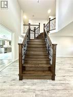 Stairway with baseboards, wood finished floors, and a towering ceiling - 