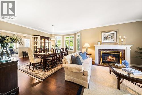 Living room with a fireplace, ornamental molding, and wood-type flooring - 4165 Stonebridge Crescent, Burlington, ON - Indoor Photo Showing Living Room With Fireplace