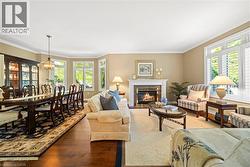 Living room featuring a fireplace, ornamental molding, hardwood / wood-style flooring, and a chandelier - 