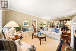 Living room featuring ornamental molding, a fireplace, and a chandelier - 