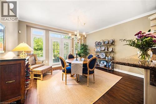 Dining room with ornamental molding, dark wood-type flooring, and a chandelier - 4165 Stonebridge Crescent, Burlington, ON - Indoor Photo Showing Dining Room