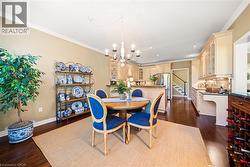 Dining area with crown molding, dark wood finished floors, a chandelier, stairs, and recessed lighting - 