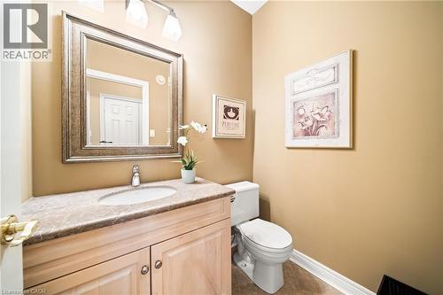 Half bathroom featuring vanity and dark tile patterned floors - 4165 Stonebridge Crescent, Burlington, ON - Indoor Photo Showing Bathroom