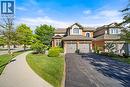 View of front of house featuring asphalt driveway, brick siding, a front lawn, a garage, and a shingled roof - 4165 Stonebridge Crescent, Burlington, ON  - Outdoor With Facade 