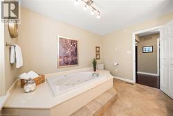 Bathroom featuring a whirlpool tub and baseboards - 