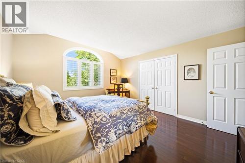 Bedroom with dark wood-style floors, a textured ceiling, a closet, and vaulted ceiling - 4165 Stonebridge Crescent, Burlington, ON - Indoor Photo Showing Bedroom