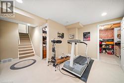 Workout room featuring a drop ceiling, light colored carpet, and recessed lighting - 