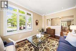 Living area with dark wood finished floors, crown molding, and recessed lighting - 