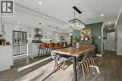 Dining space featuring dark wood-style floors, recessed lighting, and a chandelier - 