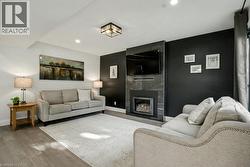 Living area with wood finished floors, a fireplace, and recessed lighting - 