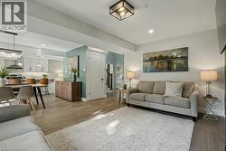 Living area with stairs, light wood-type flooring, recessed lighting, and a chandelier - 