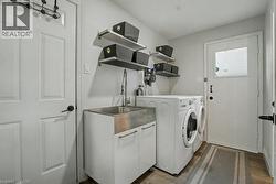 Laundry area with washer and dryer and dark wood-type flooring - 