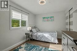 Bedroom with light wood-type flooring and baseboards - 