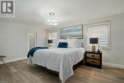 Bedroom featuring wood finished floors and a chandelier - 