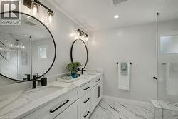 Bathroom with a marble finish shower, double vanity, light marble finish flooring, and recessed lighting - 