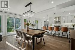 Dining space featuring light wood-style flooring, a chandelier, and recessed lighting - 