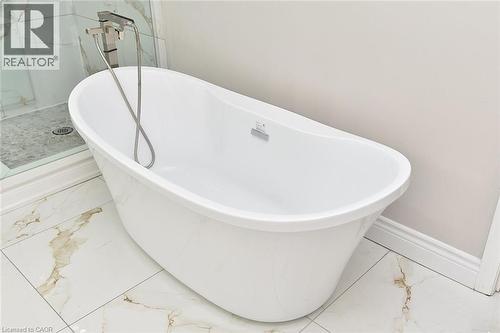 Full bathroom featuring marble look tile flooring and a freestanding tub - 5109 Blue Spruce Avenue, Burlington, ON - Indoor Photo Showing Bathroom