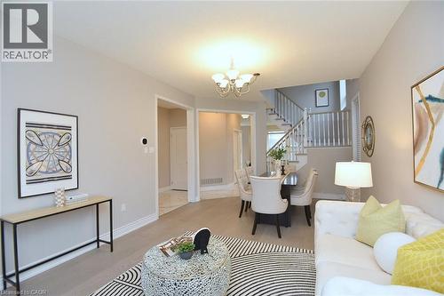 Living room with a chandelier, wood finished floors, and stairs - 5109 Blue Spruce Avenue, Burlington, ON - Indoor