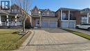 View of front facade featuring decorative driveway, brick siding, a front lawn, a porch, and a garage - 3688 Emery Drive, Mississauga, ON  - Outdoor With Facade 