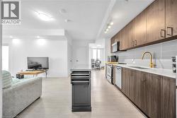 Kitchen with a kitchen island, open floor plan, modern cabinets, decorative backsplash, and stove - 