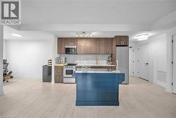 Kitchen featuring stainless steel counters, stainless steel appliances, backsplash, a kitchen island, and modern cabinets - 
