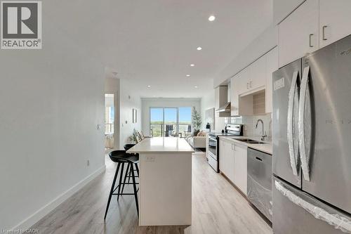 Kitchen featuring appliances with stainless steel finishes, a kitchen island, white cabinets, modern cabinets, and recessed lighting - 15 Glebe Street Unit# 1511, Cambridge, ON - Indoor Photo Showing Kitchen With Upgraded Kitchen