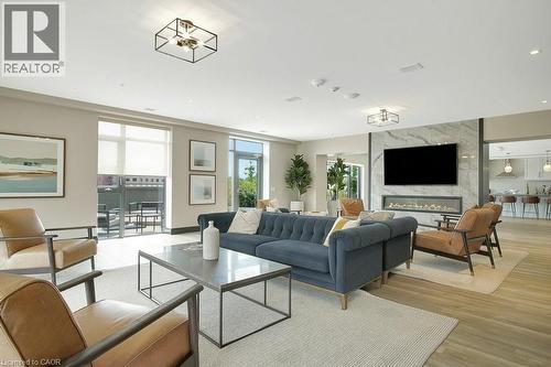 Living room with light wood-style flooring, plenty of natural light, a high end fireplace, and recessed lighting - 15 Glebe Street Unit# 1511, Cambridge, ON - Indoor Photo Showing Living Room With Fireplace