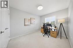 Home office with light colored carpet and baseboards - 