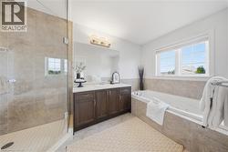 Full bathroom with vanity, a whirlpool tub, a stall shower, and light tile patterned floors - 