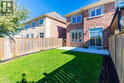 Back of property featuring brick siding, a patio, and a fenced backyard - 