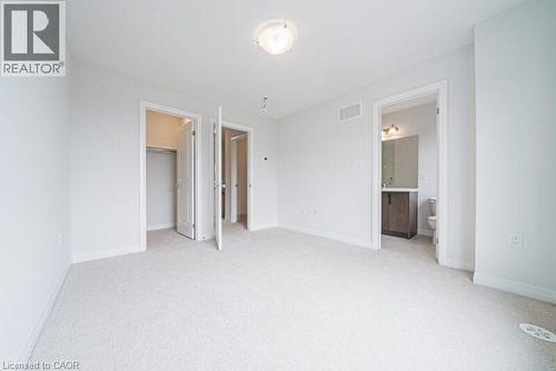 Unfurnished bedroom featuring a spacious closet, light carpet, and ensuite bath - 155 Equestrian Way Unit# 22, Cambridge, ON - Indoor Photo Showing Other Room