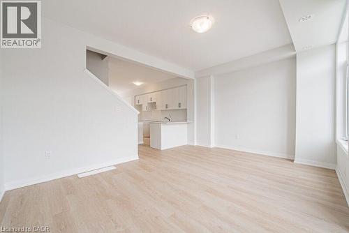 Unfurnished living room with light wood-style flooring and baseboards - 155 Equestrian Way Unit# 22, Cambridge, ON - Indoor Photo Showing Other Room