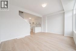 Unfurnished living room with light wood-style flooring and baseboards - 