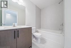 Full bath featuring shower / bathtub combination, vanity, and light tile patterned floors - 