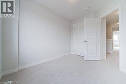 Unfurnished bedroom with light colored carpet and baseboards - 