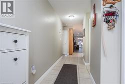 Hall with light tile patterned flooring and baseboards - 