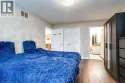 Bedroom featuring dark wood-style floors, a closet, and connected bathroom - 