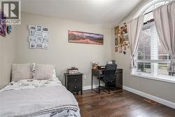 Bedroom featuring lofted ceiling, dark wood-style floors, and an office area - 